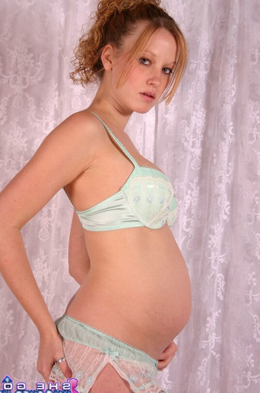 12P Schwangere Teenagerin bedeckt ihre nackten Brüste und zeigt dabei ihren geschwollenen Bauch