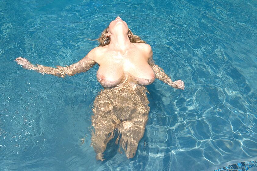17P La MILF toujours excitée Kelly Madison tient ses gros seins sous le bec d'eau