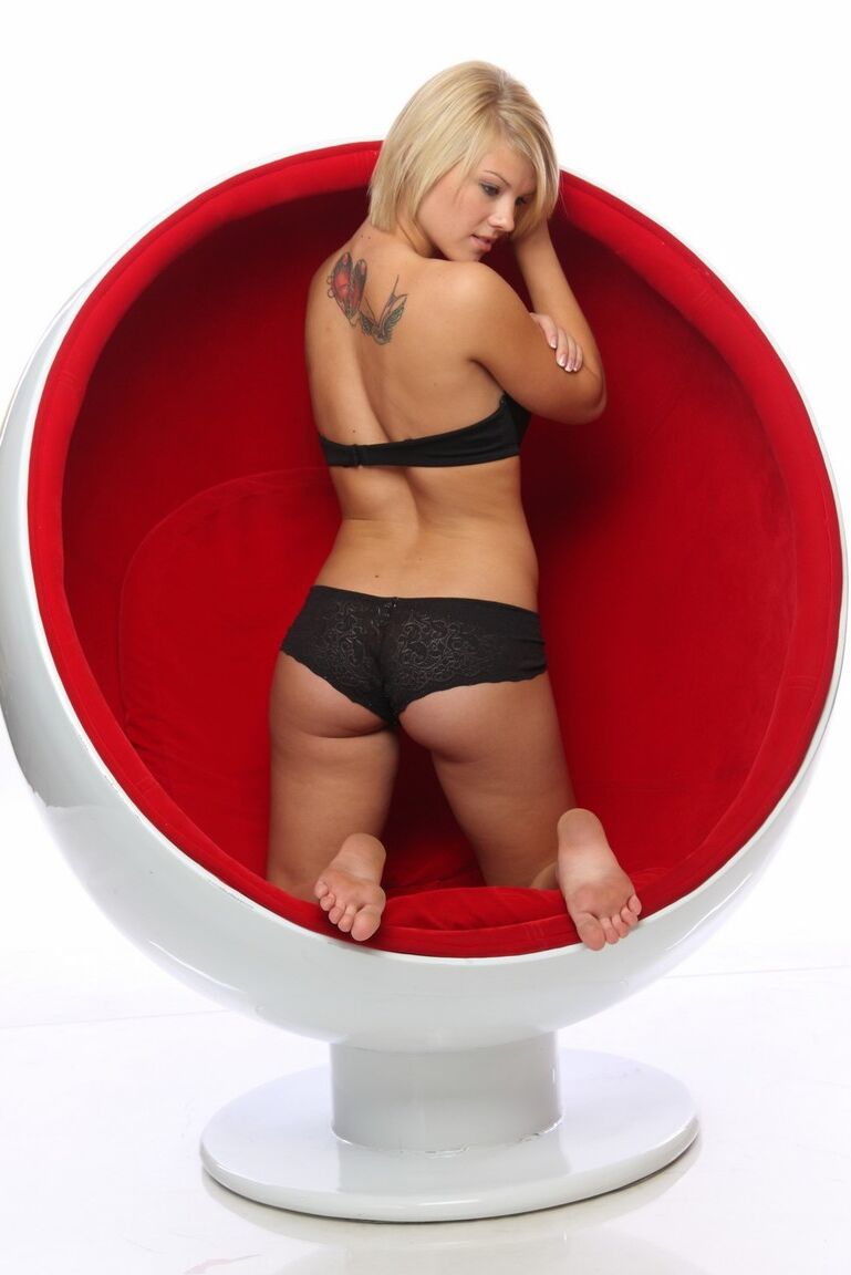 16P Modelos de uma jovem loira em uma cadeira vermelha usando um conjunto de sutiã e calcinha pretos