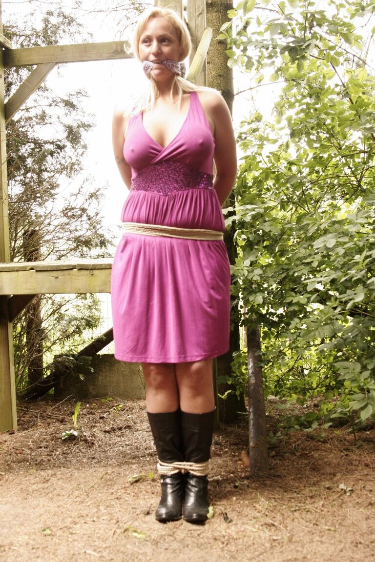 17P Stacked blonde Deedee tied up with rope & gagged outdoors with her tits bared