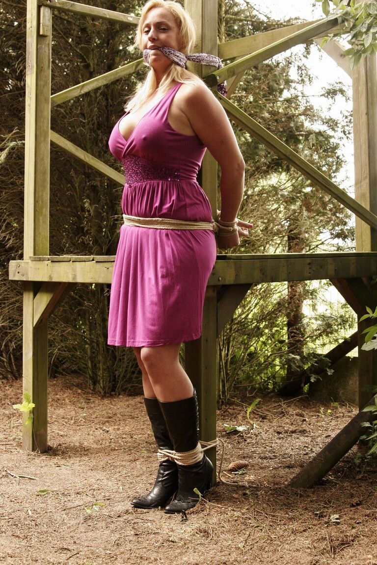 17P Stacked blonde Deedee tied up with rope & gagged outdoors with her tits bared