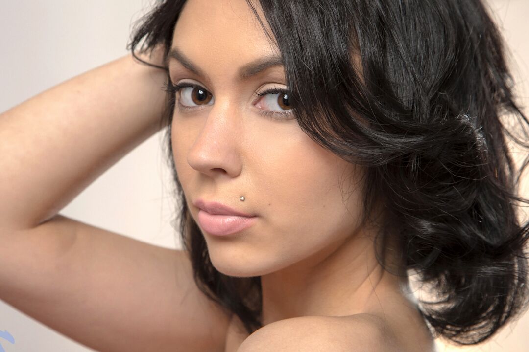 15P La joven de pelo oscuro Sheri Vi se separa los labios del coño después de desnudarse en un sofá