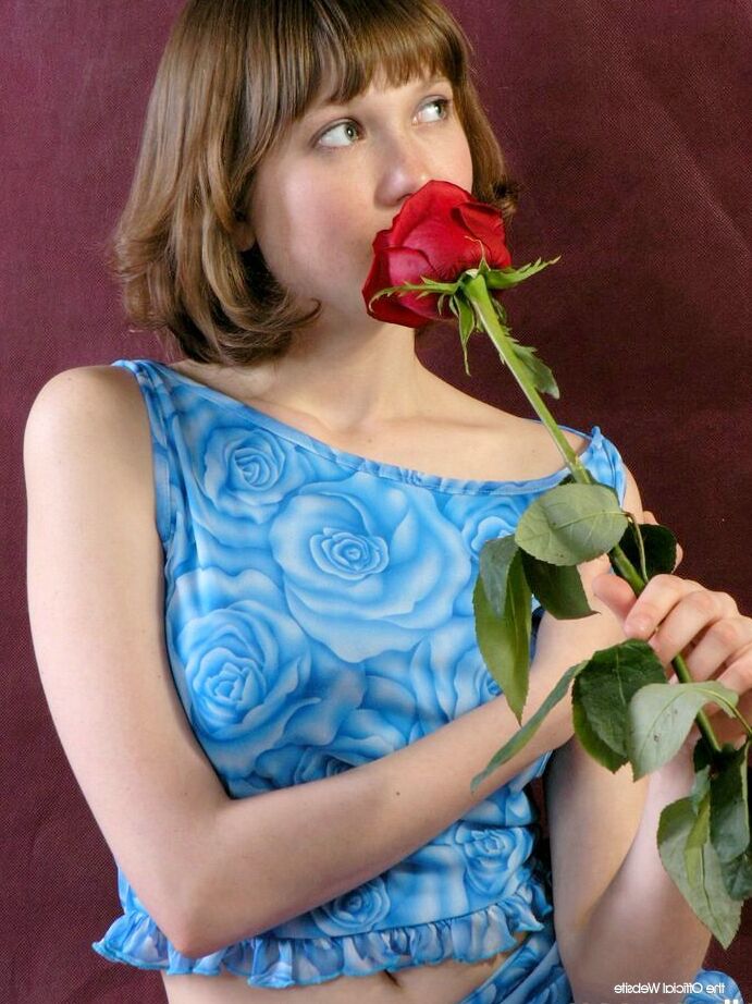 16P A adorável adolescente Anabell cheira uma rosa vermelha antes de tirar a roupa
