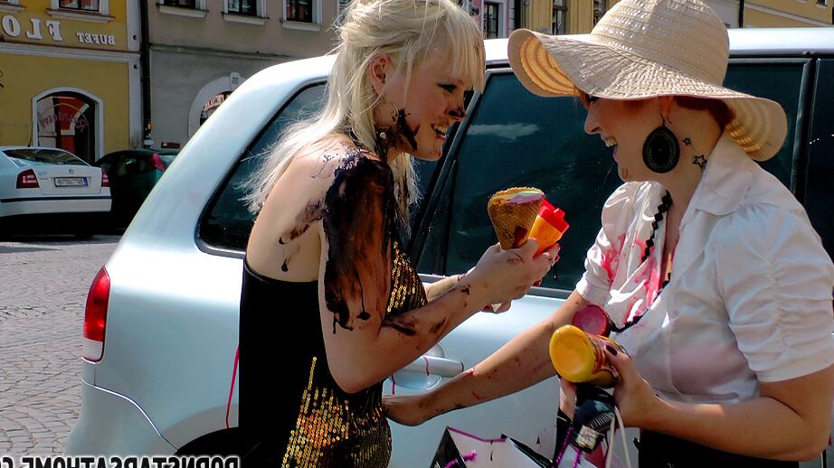14P Les femmes fermées se couvrent de produits alimentaires entre les voitures garées