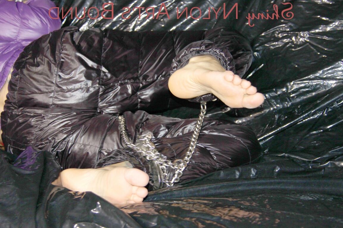 16P Sandra ist mit Handschellen und einem Pranger in heißem Lila auf einem Sofa gefesselt und geknebelt