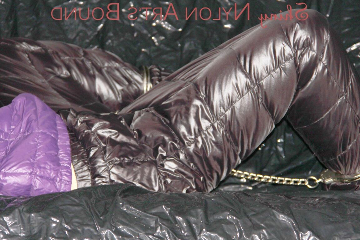 16P Sandra ist mit Handschellen und einem Pranger in heißem Lila auf einem Sofa gefesselt und geknebelt