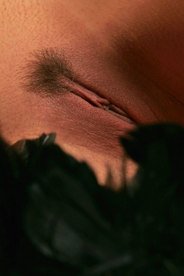 12P Joven morena empuña una boa mientras posa desnuda con guantes de terciopelo negro