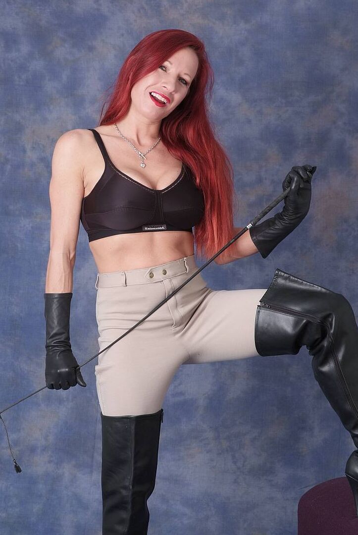 15P Dominant redhead Faye bares her fake tits while flexing a whip in leather wear