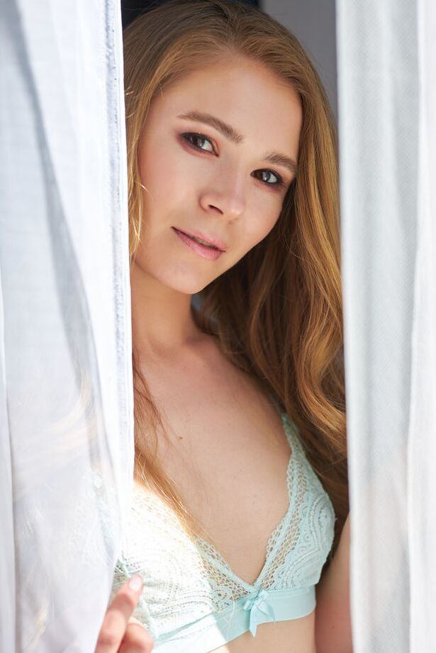 18P A beleza sensual sorri sedutoramente enquanto tira sua lingerie sexy em um