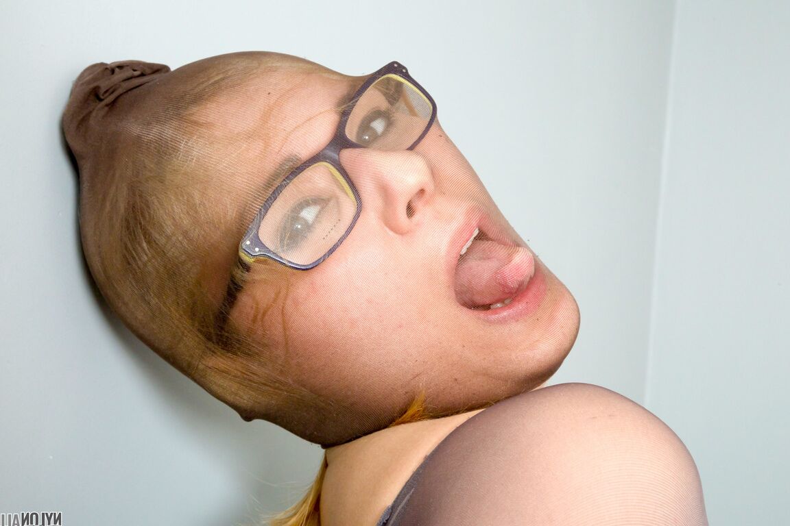 16P Geeky blonde porte ses lunettes tout en se superposant avec des collants sur un lit