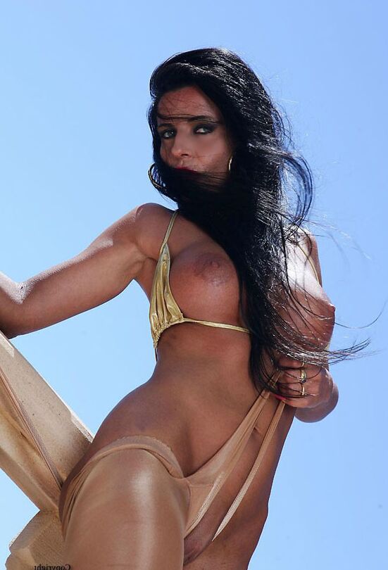 15P Brunette model Model Eve pulls om shiny pantyhose on seaside balcony