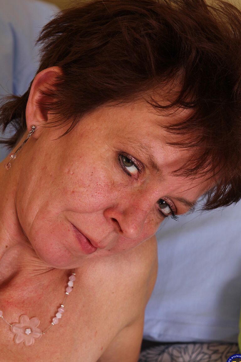 21P Short-haired granny undresses and massages her fuzzy crotch on the bed