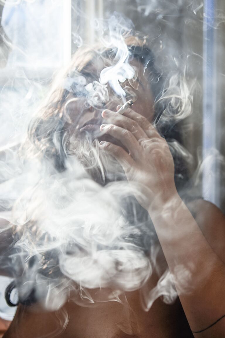21P Amateur babe Nikki Silver smokes a spliff while posing naked indoors and out