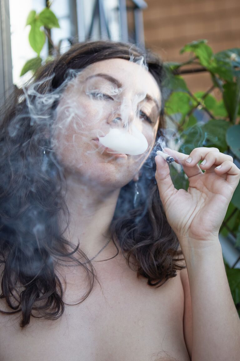 21P Amateur babe Nikki Silver smokes a spliff while posing naked indoors and out