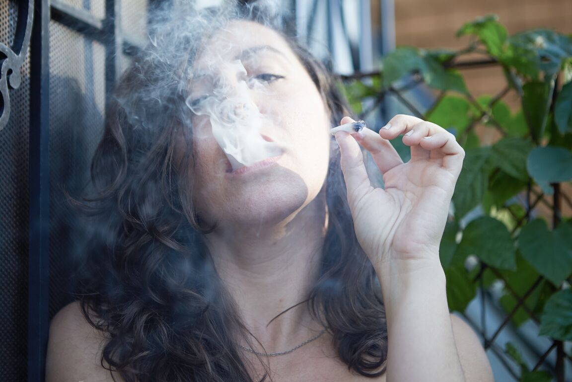 21P Amateur babe Nikki Silver smokes a spliff while posing naked indoors and out