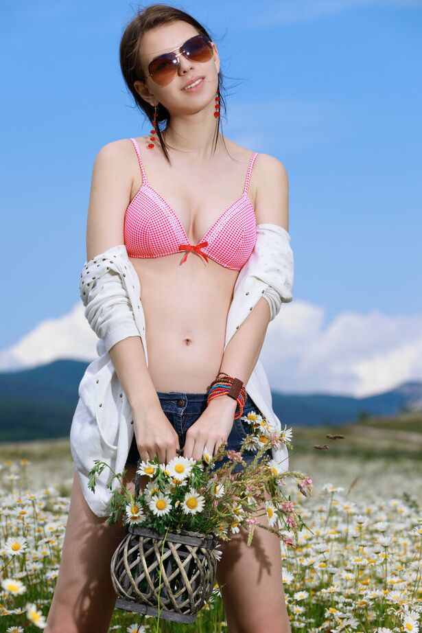18P La simpática joven Karolina Young se quita las gafas de sol mientras se desnuda en un campo