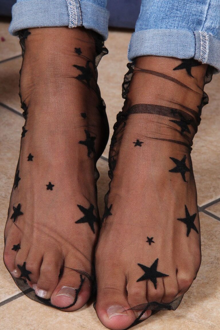 12P Une femme vêtue libère ses pieds nus de ses talons et de ses chaussettes sexy en nylon