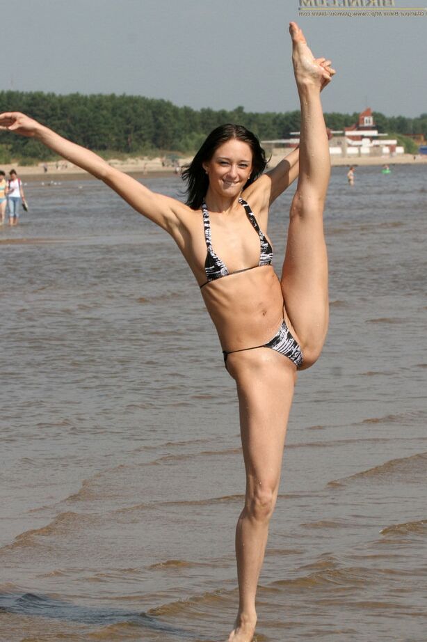 20P Slim brunette takes off her bikini top while standing in shallow water