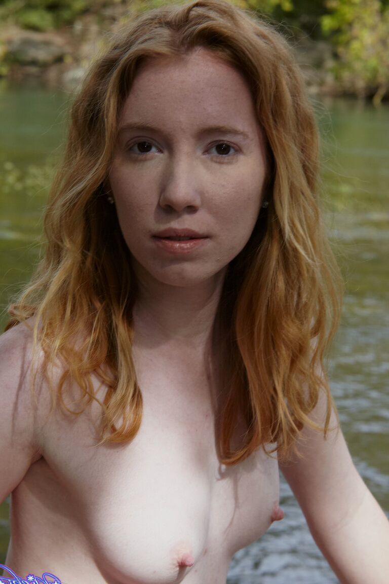 15P Young redhead Nicki Blue bare her small tits while standing in a stream