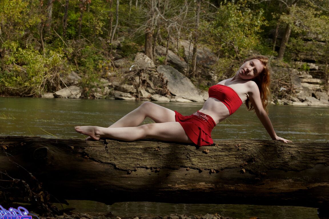 15P Young redhead Nicki Blue bare her small tits while standing in a stream