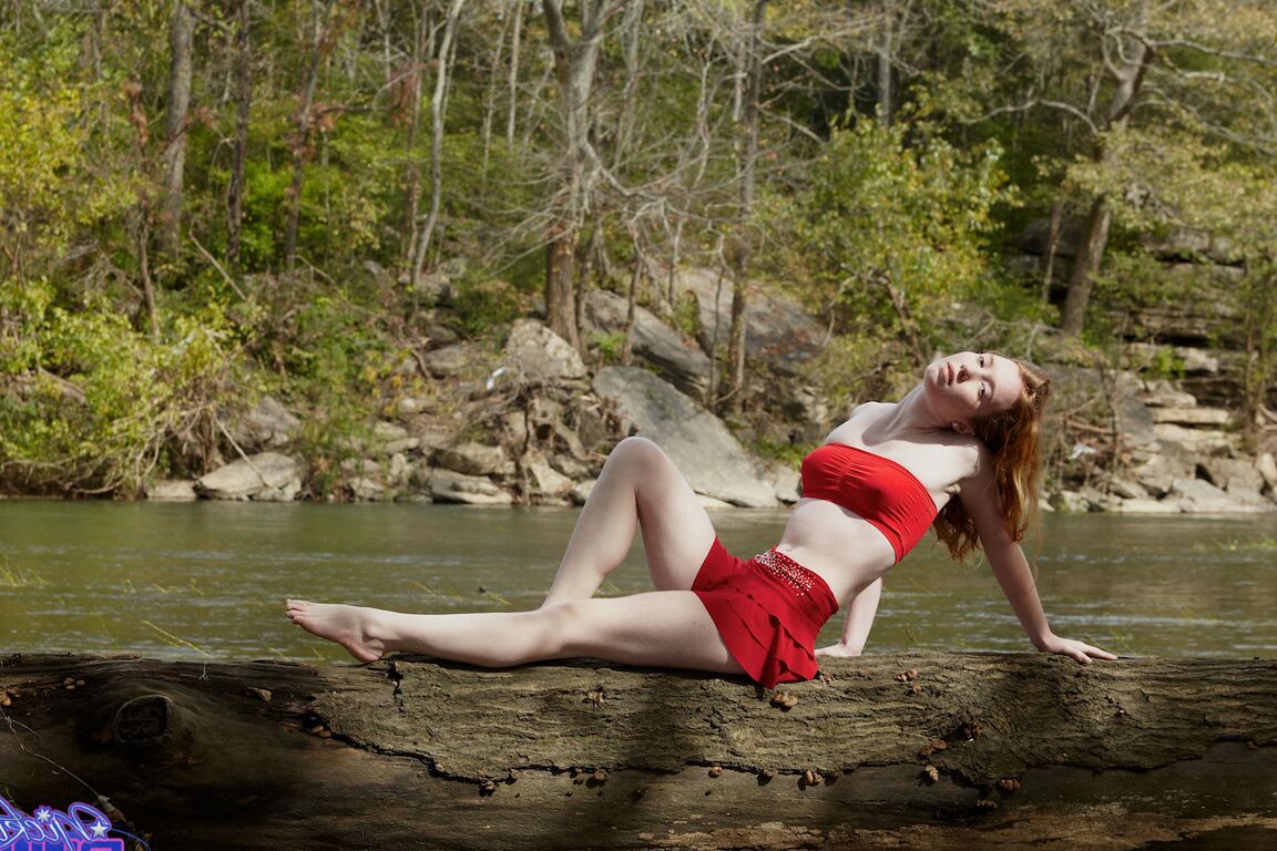 15P Young redhead Nicki Blue bare her small tits while standing in a stream