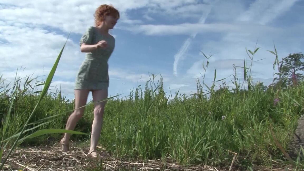 15P Redhead babe pees over a massive rock outside