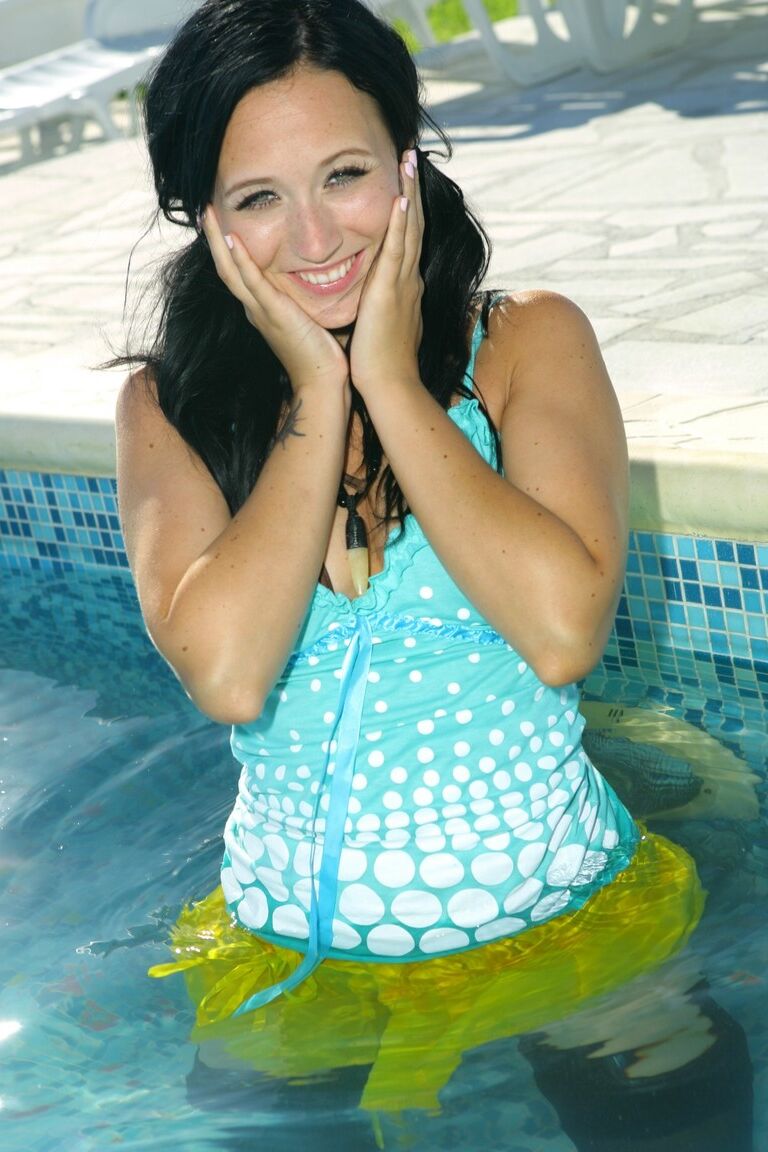 21P Black haired Penelope exposes her small boobs and poses in stockings poolside