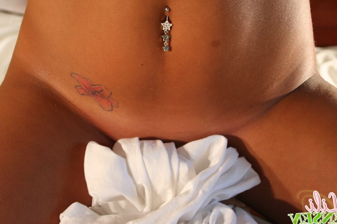 12P A adolescente amadora Lili Jensen coloca as mãos nos seios enquanto mostra um piercing na barriga