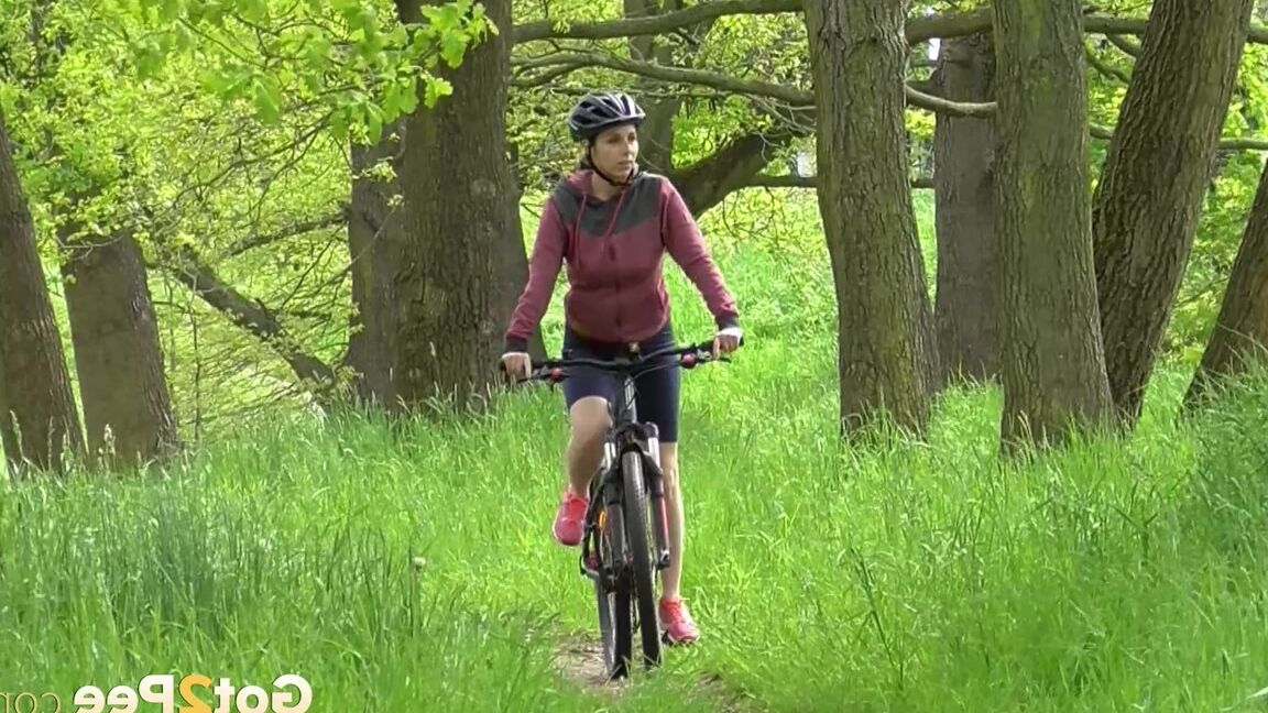 15P ソロ少女アントニア・サインツが森の中の小道で自転車に乗りながらおしっこをするためにしゃがむ