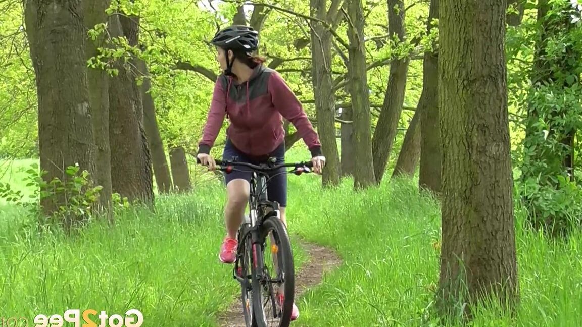 15P ソロ少女アントニア・サインツが森の中の小道で自転車に乗りながらおしっこをするためにしゃがむ