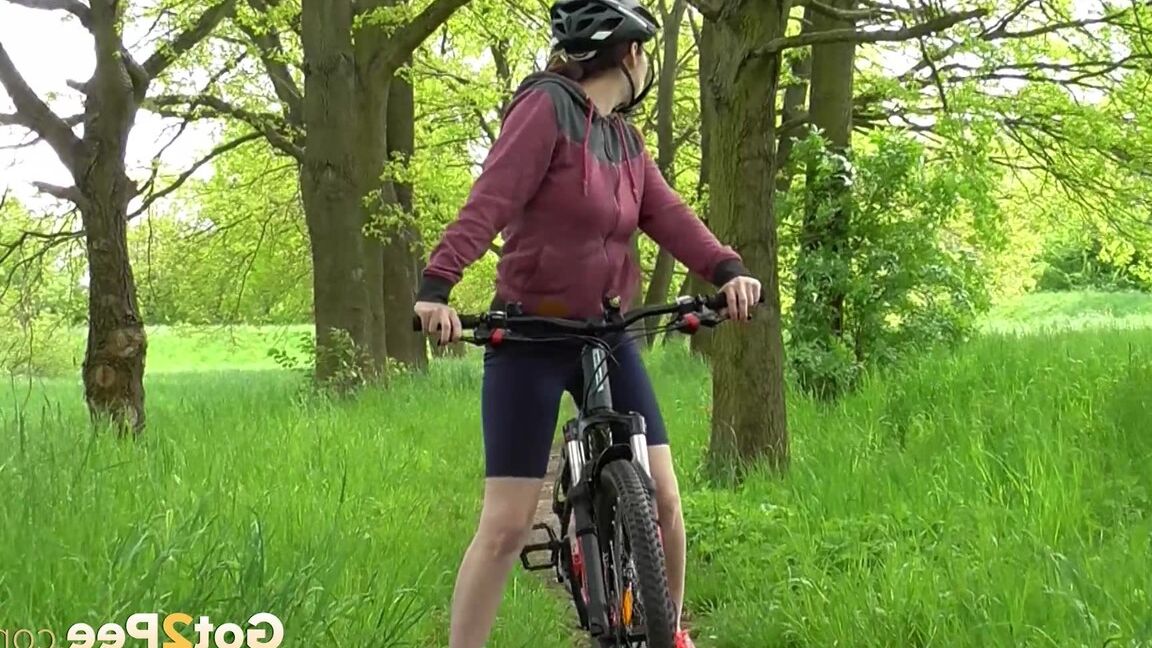 15P ソロ少女アントニア・サインツが森の中の小道で自転車に乗りながらおしっこをするためにしゃがむ