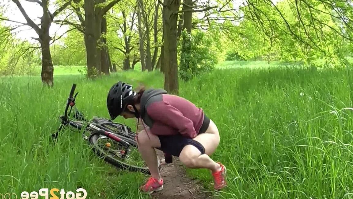 15P ソロ少女アントニア・サインツが森の中の小道で自転車に乗りながらおしっこをするためにしゃがむ
