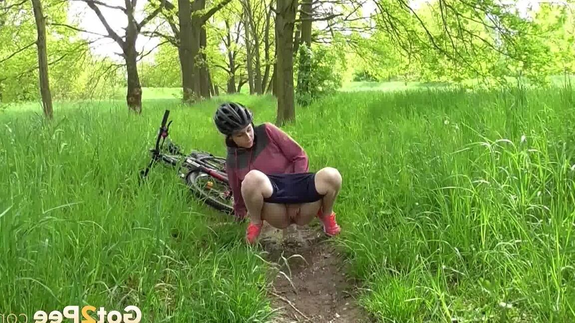 15P ソロ少女アントニア・サインツが森の中の小道で自転車に乗りながらおしっこをするためにしゃがむ