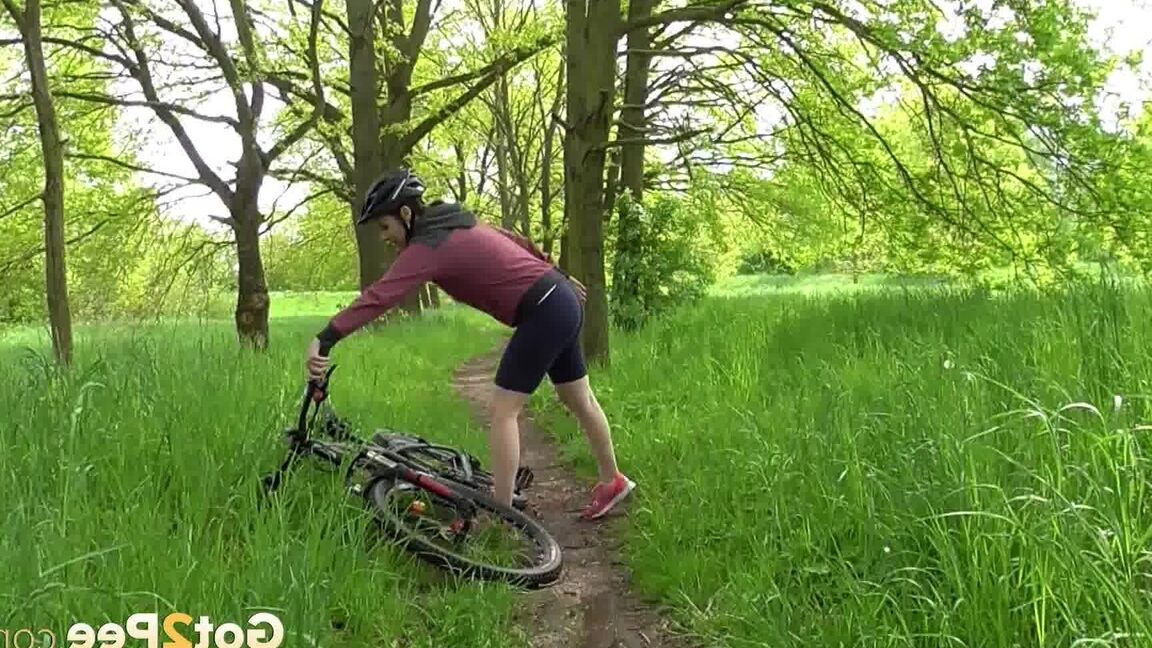 15P ソロ少女アントニア・サインツが森の中の小道で自転車に乗りながらおしっこをするためにしゃがむ