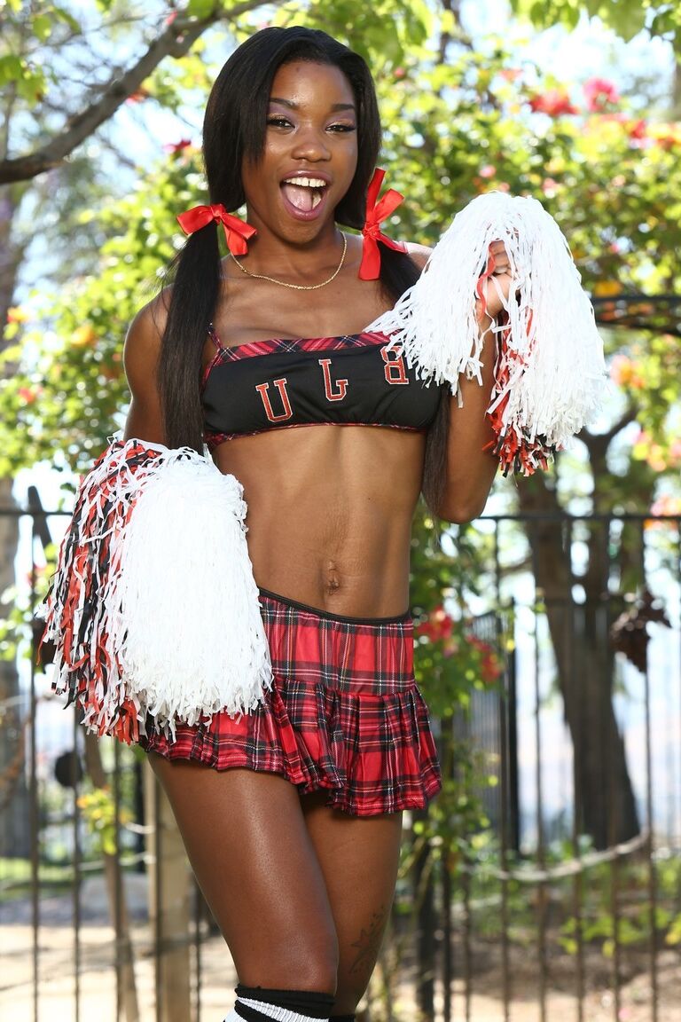 21P Mya Mays, pom-pom girl ébène impertinente, s'étale pour une jupe haute nue avec les seins exposés.