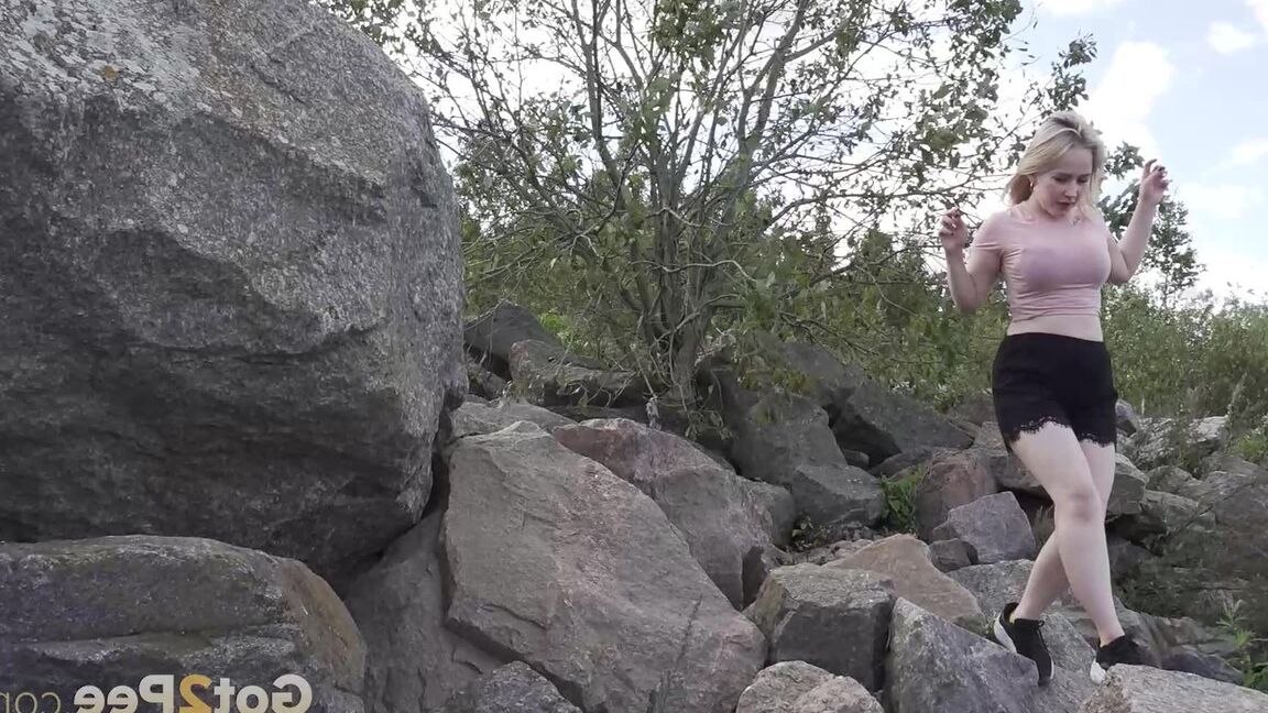 15P Une blonde chaude baisse son short pour pisser sur des rochers