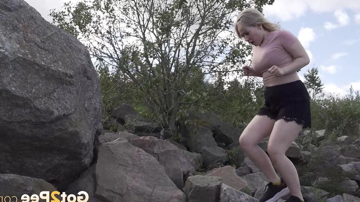 15P Une blonde chaude baisse son short pour pisser sur des rochers