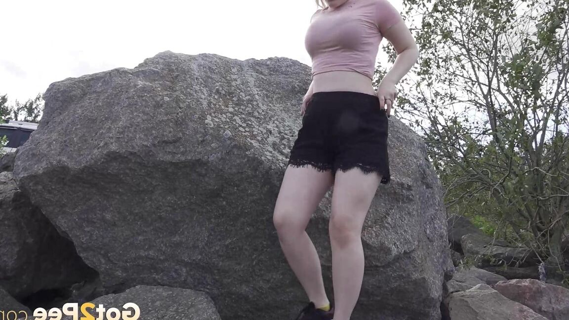 15P Une blonde chaude baisse son short pour pisser sur des rochers