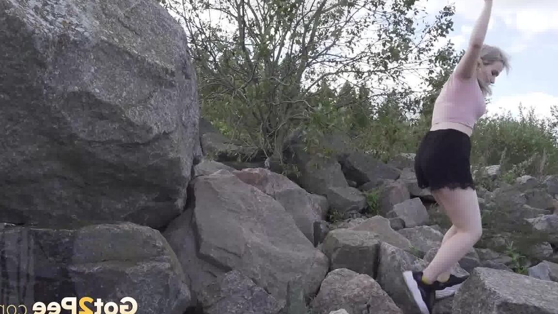 15P Une blonde chaude baisse son short pour pisser sur des rochers