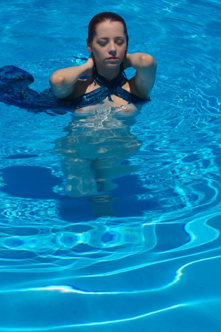 12P Busty redhead Ariel exits a swimming pool to pose totally naked