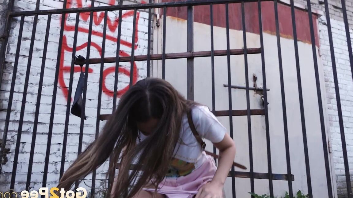 15P Distressed girl Sasha S lifts up a skirt before taking a pee behind a building