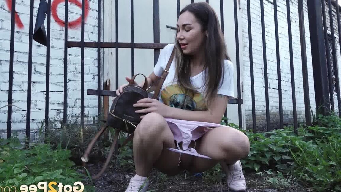 15P Distressed girl Sasha S lifts up a skirt before taking a pee behind a building