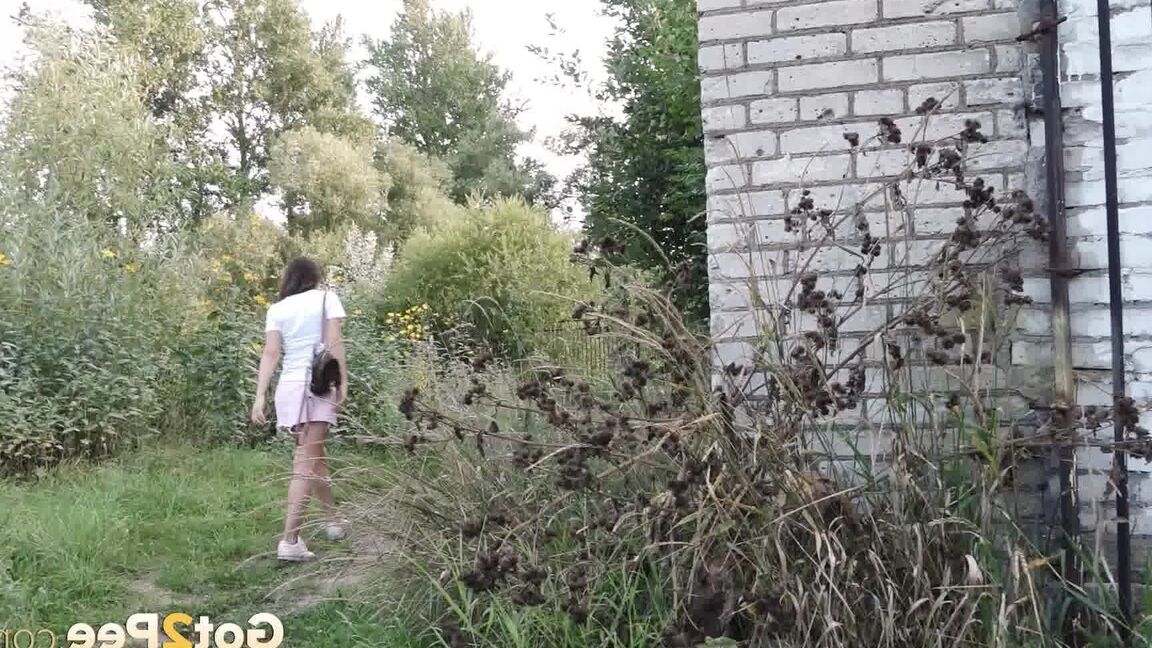 15P Distressed girl Sasha S lifts up a skirt before taking a pee behind a building
