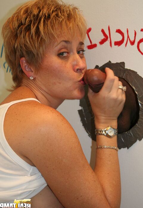 Die 15P reife Rothaarige Tracy Lick trägt kurzes Haar, während sie an einem Gloryhole einen BBC lutscht