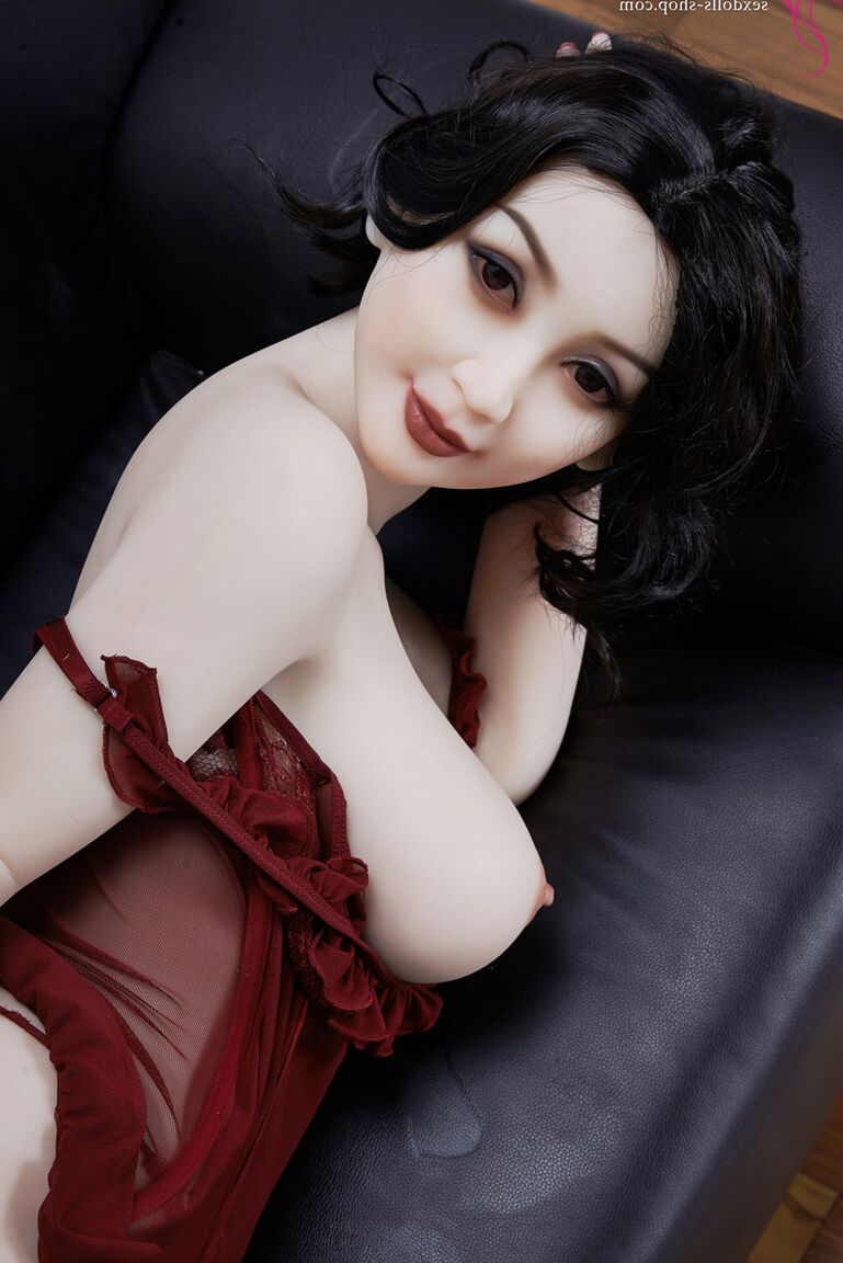 21P La muñeca sexual de pelo oscuro Xiu hace alarde de sus grandes tetas y su gran culo en un sofá negro