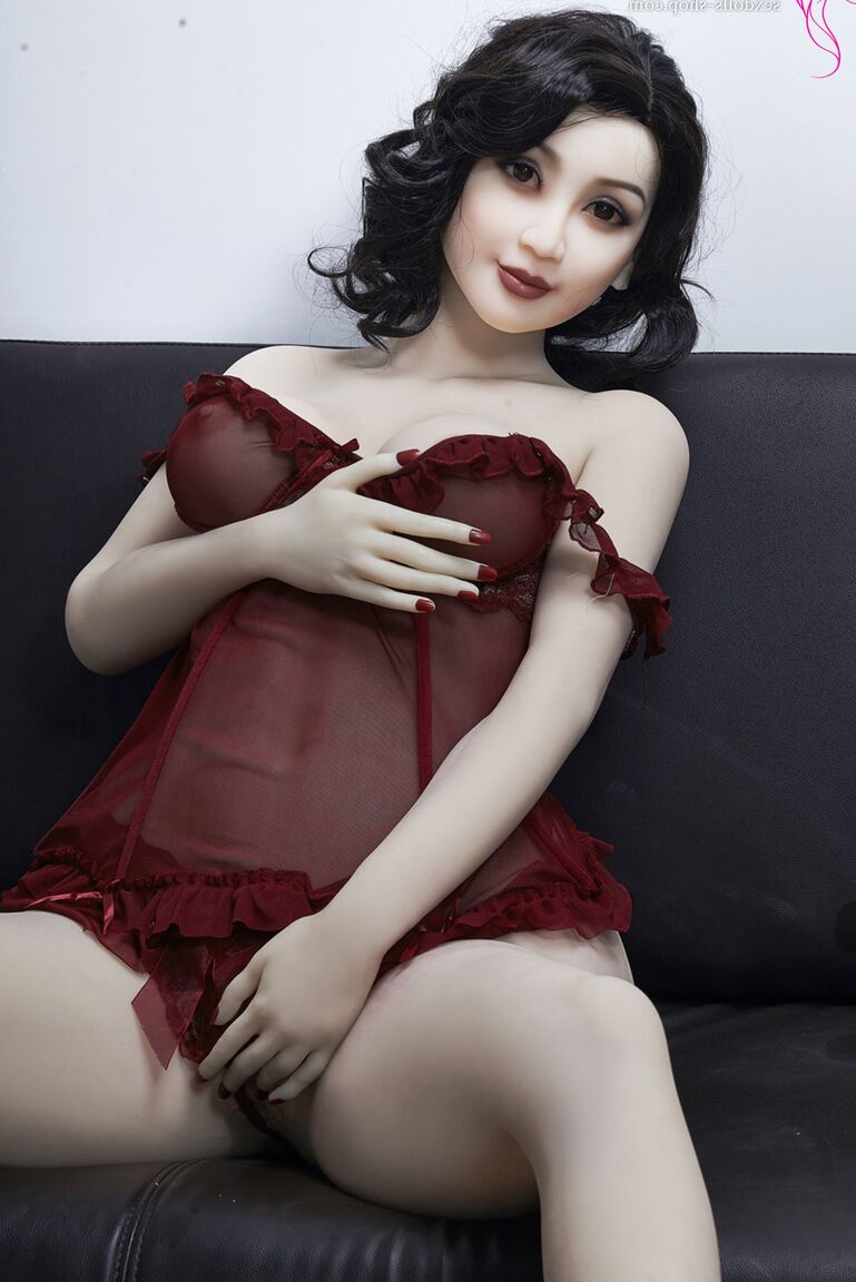 21P La muñeca sexual de pelo oscuro Xiu hace alarde de sus grandes tetas y su gran culo en un sofá negro