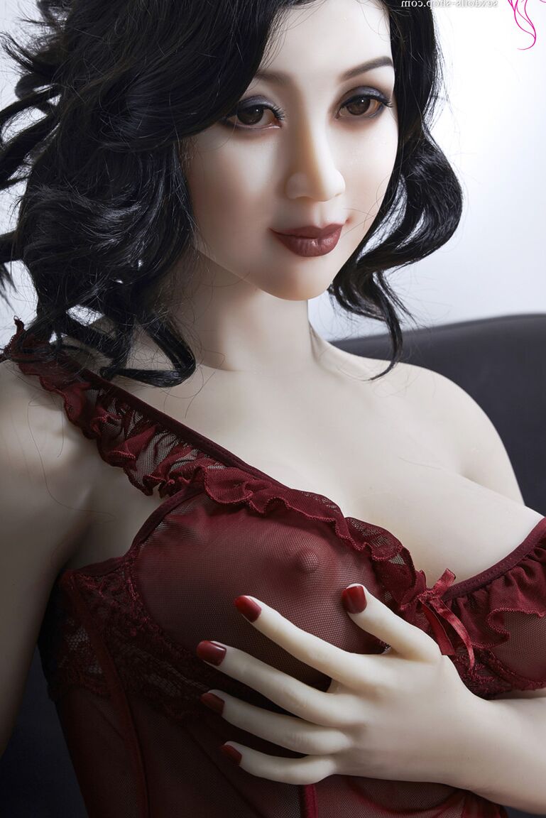 21P La muñeca sexual de pelo oscuro Xiu hace alarde de sus grandes tetas y su gran culo en un sofá negro