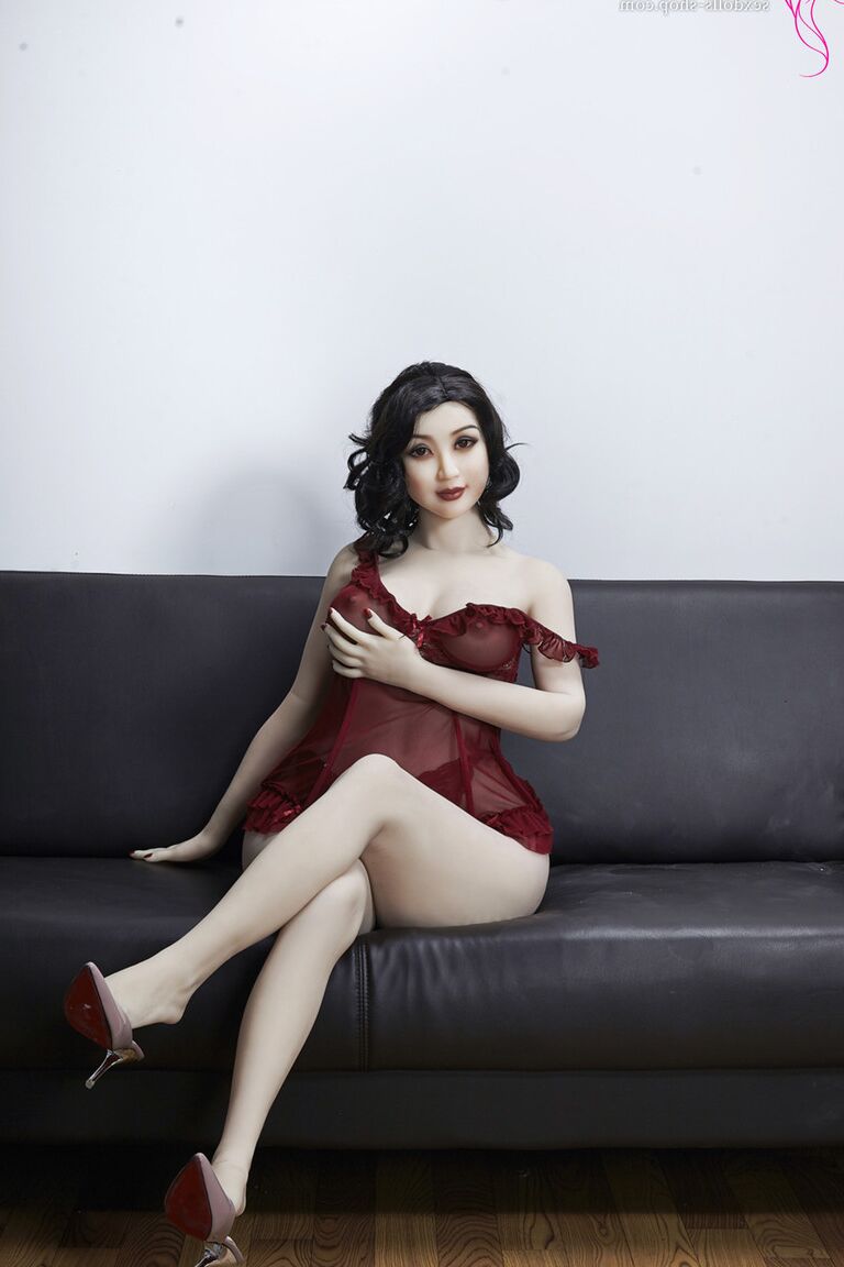 21P La muñeca sexual de pelo oscuro Xiu hace alarde de sus grandes tetas y su gran culo en un sofá negro