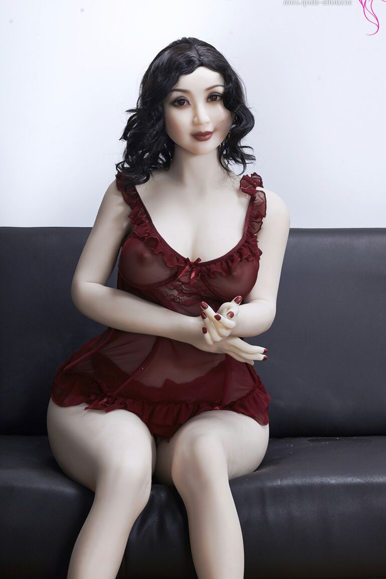 21P La muñeca sexual de pelo oscuro Xiu hace alarde de sus grandes tetas y su gran culo en un sofá negro
