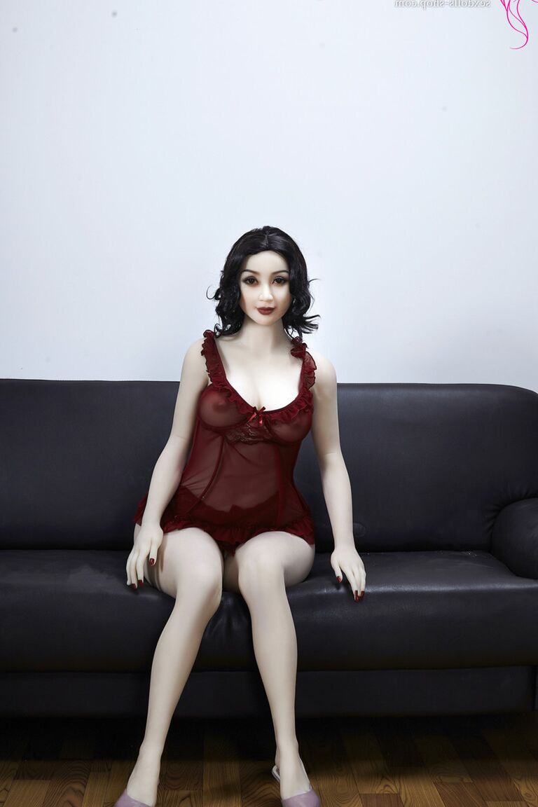 21P La muñeca sexual de pelo oscuro Xiu hace alarde de sus grandes tetas y su gran culo en un sofá negro